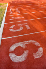 Running track start line with lane numbering 1 to 6 .Rubber aggregate mix paving surface