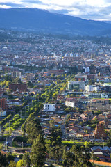 Fototapeta premium View of the city of Cuenca, Ecuador, with it's many churches and rooftops, on a cloudy and sunny day