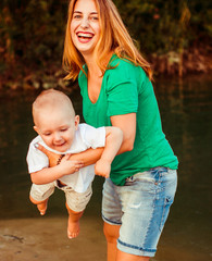 Fototapeta premium Mother play with a baby on the lake