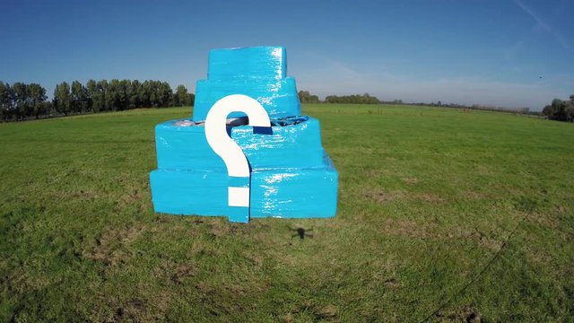 Aerial irony or white marks on small bright blue structure drone flying towards cube with? then hoovers close to it usefull showing quadcopter shadow footage could indicate FAA drone regulations 4k