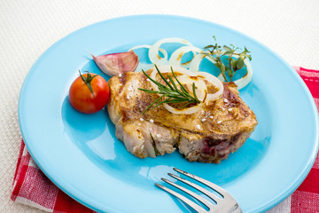 Juicy grilled pork chop with onion rings