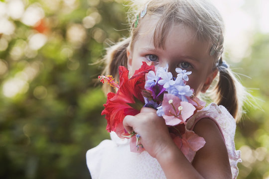 Young girl smelling colorful bouquet of flowers