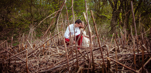 Look through the dry branches at thoughtful couple sitting on th