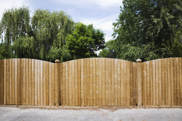 A Wooden Fence With Trees Behind It; British Columbia, Canada
