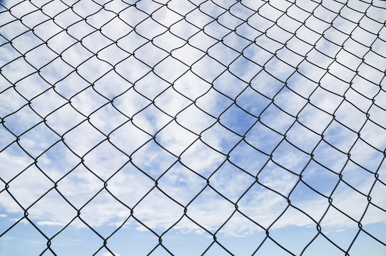 Chain Link Fence And Blue Sky With Cloud; Canada