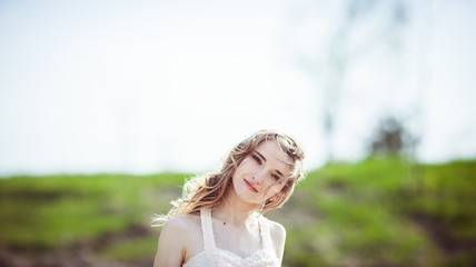 Portrait of beautiful dark blonde lady standing in soft spring s