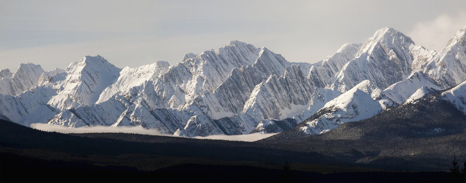 Snow covered mountain range with cloud in valley;Kananaskis alberta canada