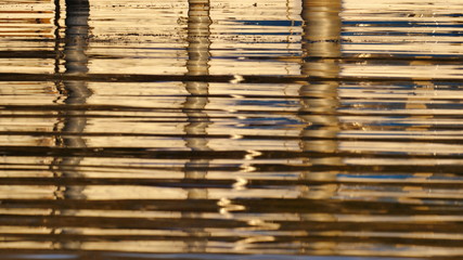 Goldene Wasseroberfläche mit Spiegelung