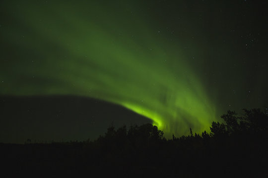 Aurora borealis cutting a swath across the night sky;Alberta, canada