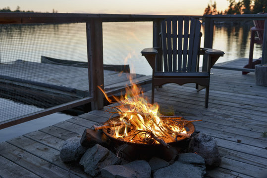 Fire pit on a wooden dock on a lake at sunset;Lake of the woods ontario canada