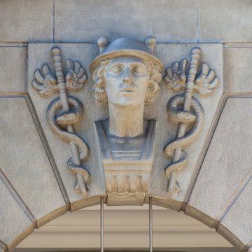 Carved symbol of snakes sceptres and a head above a doorway;Zurich switzerland