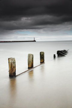 Wooden posts in the tranquil water;Berwick northumberland england