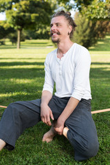 Fototapeta premium portrait of man sitting on slackline and balancing on a rope