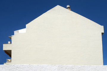 White facade of the house on background blue sky