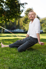 Fototapeta premium portrait of man sitting on slackline and balancing on a rope