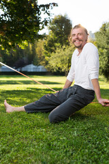 Fototapeta premium portrait of man sitting on slackline and balancing on a rope