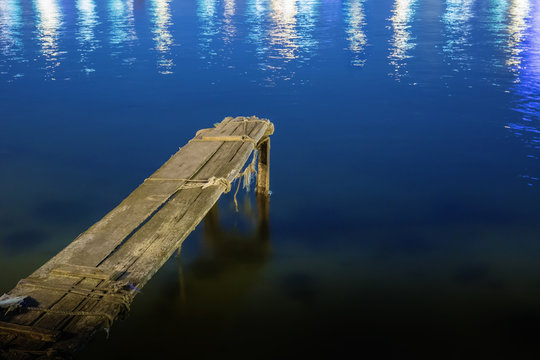 old dilapidated wooden pier at night