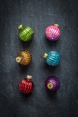 Colorful christmas balls on black chalkboard from above