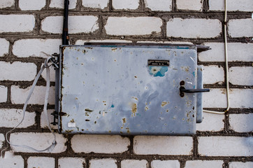 old electric box on concrete wall with steel tube and plug / Smart Electric Utility Meter / outdoor cabinet for electrical equipment / Electric control box / Main circuit box breaker in factory