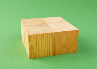 wooden geometric cube on a green background