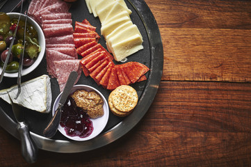 a plate of sliced cheeses and meats