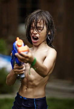 Young boy playing with a water gun; Markham, Ontario, Canada