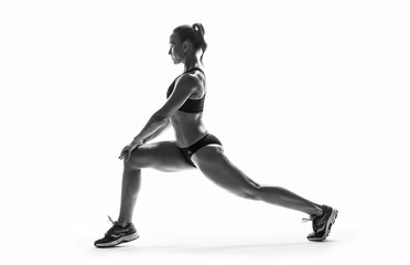 Fototapeta na wymiar Athletic young woman doing stretching fitness exercise, isolated. Intense stretch pose