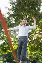 Guy practising slack line in the city park