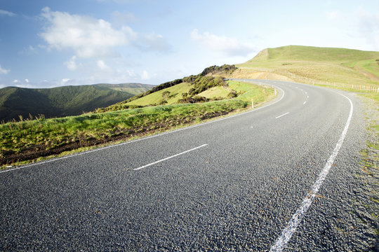 Scenic view of curving mountain road against cloudy sky