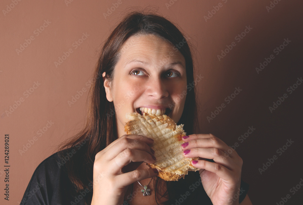 Wall mural Woman eating sandwich