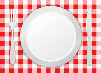 Fork, knife and plate on tablecloth 