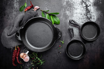 cast iron pan and spices on black metal culinary background, view from above © Sea Wave