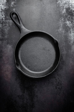 cast iron pan on black metal culinary background, view from above