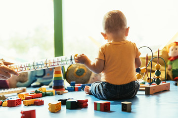 Happy baby playing with toy blocks. © santypan
