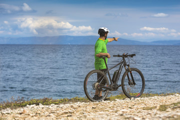 Obraz premium Mountainbiker mit Ebike am Meer