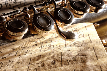 Detail transverse flute on old handwritten sheet music