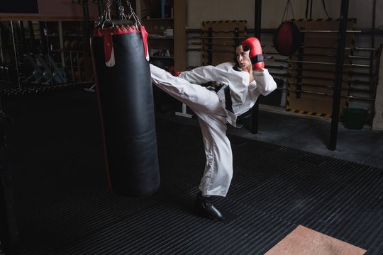 Woman practicing karate with punching bag