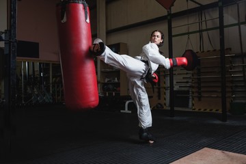 Woman practicing karate with punching bag