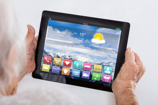 Senior Woman Holding Digital Tablet Showing App