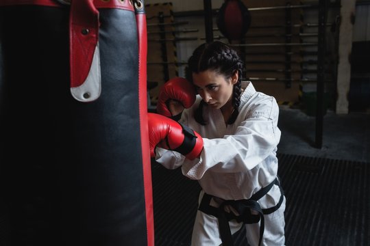 Woman practicing karate with punching bag