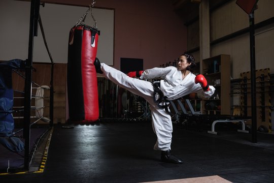 Woman practicing karate with punching bag