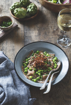 Chestnut flour ravioli with artichokes, peas, broth, and enoki m