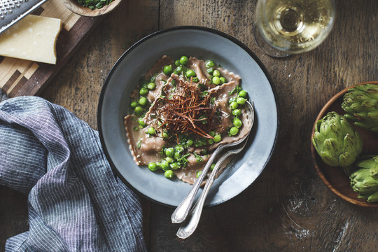 Chestnut flour ravioli with artichokes, peas, broth, and enoki m