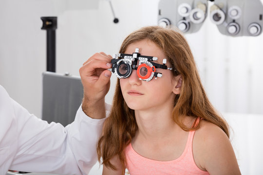 An Optometrist Checking Girl's Vision With Trial Frame