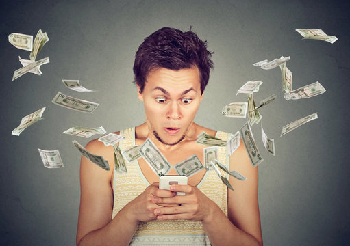 surprised man using smartphone dollar bills flying away from screen