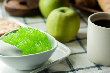 apple jam and crackers, coffee cup on the table, light from the window