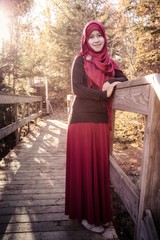 A pregnant muslim woman with natural background during autumn season