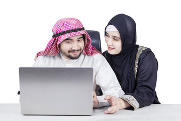 Muslim couple using laptop