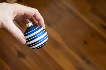 Man holding a Christmas bauble in his fingers