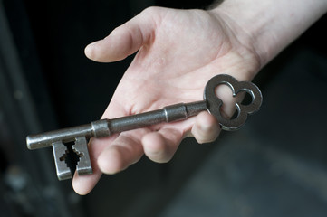 Hand holding a big iron vintage key